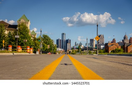 An Empty Street Through An Old Detroit City Neighborhood With Downtown Buildings In The Background