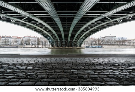 Empty street under a bridge in Lyon on a grey, winter day in February.