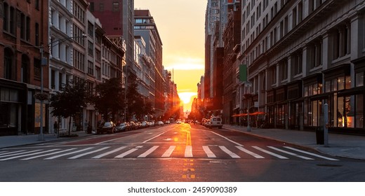 Empty streets and sidewalks at 5th Avenue and 23rd St in New York City with sunset shining between the buildings of the Manhattan cityscape - Powered by Shutterstock