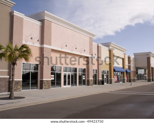 empty\
strip mall with pastel stucco and stone\
accents