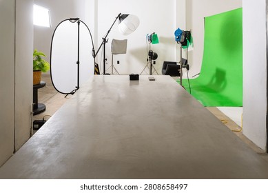 Empty studio with green screen background and professional lighting equipment for video production
