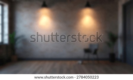 An empty studio space with a brick wall, overhead lighting, and a wooden floor. The room is dimly lit, creating a moody atmosphere.