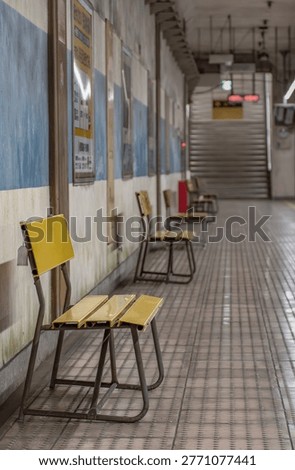 Empty subway station platform with concrete pillars and blue stripes, underground railway in Japan.