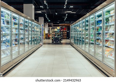 Empty supermarket aisle with freezers showcases with different products