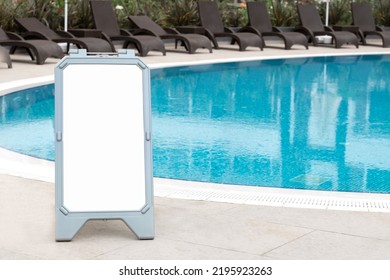 Empty Swimming Pool With Blue Transparent Water, No People. Warning Sign, Rules, Mock-up, Copy Space For Text.Information Board On White Background.