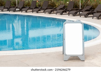 Empty Swimming Pool With Blue Transparent Water, No People. Warning Sign, Rules, Mock-up, Copy Space For Text.Information Board On White Background.