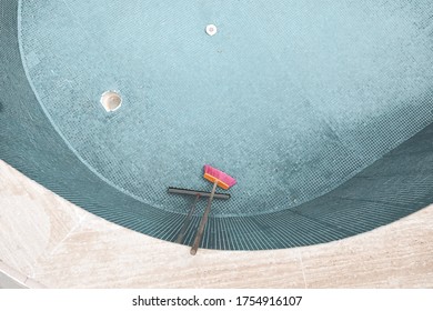 Empty Swimming Pool And Cleaning Brush