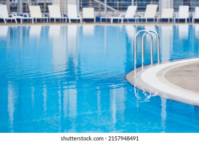 Empty Swimming Pool With Clear Blue Water And Sun Loungers Without People In The Hotel