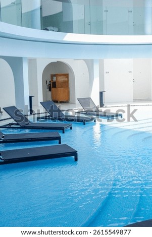 Empty swimming pool with sunbed and white modren resort hotel for vacation leisure and white sand,resort neary sea and beach in summer.