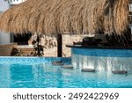 Empty Swim-Up Bar with Straw Canopy in Tropical Resort