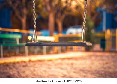 An Empty  Swin Hang At The Playground. No Children Are Playing On The Swing Set, Which Is Not Moving. The Swings Are Clean And Well Maintained. Back To School. Recess Equipment. Outdoors.