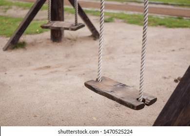 Empty swing on children playground,Children swing in the park,wooden swing,wooden swing on the lawn during