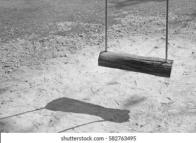 Empty swing with shadows in black and white style
