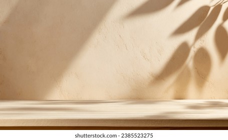 Empty table against beige textured wall background. Composition with glossy leaves  on the wall.