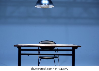 An empty Table and chair with hanging light bulb in room,  Investigation room concept
