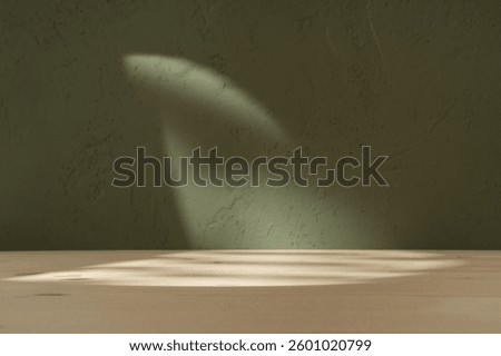 Empty table and darkgreen wall. Table with sun reflections and leaves shadows on khaki green wall. Background for presentation, branding products, cosmetics food 