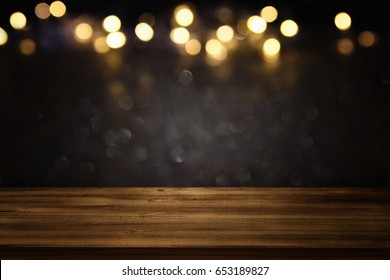 Empty Table In Front Of Black And Gold Glitter Lights Background. For Product Display Montage