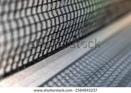 empty table with grid black mesh tabletennis, table tennis net in a blue ping pong table. standard ping pong table has a net stretched across the middle. games for office workers to have fun.