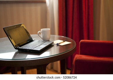 Empty table with laptop and cup