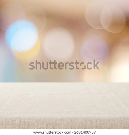 Empty table with linen tablecloth over blurred abstract with bokeh background banner, food and product display montage template, backdrop, wallpaper