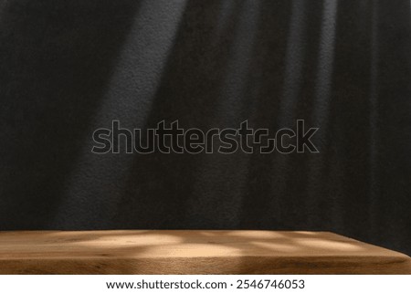 Empty table on black texture wall background. Composition with abstract shadows on wall and light reflections. Mock up for presentation, branding products, cosmetics food or jewelry.