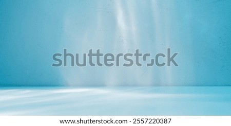  Empty table on blue wall background. Composition with abstract light reflections and shadows. Mock up with blurry spotlight for winter presentation, branding products, cosmetics and food.