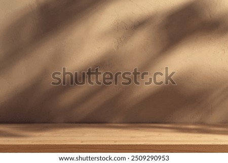 Empty table on bright brown wall background. Composition with leaves shadow on the wall and wood desk. Mock up for presentation, branding products, cosmetics, food or jewellery.
