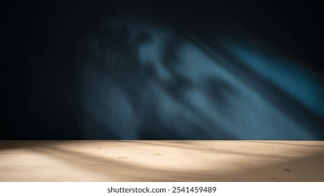 Empty table on dark blue texture wall background. Composition with organic shadow on the wall and light reflections. Mock up for presentation, branding products, cosmetics food or jewelry.