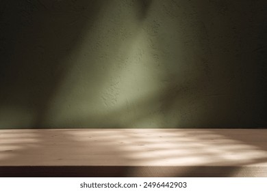 Empty table on dark green texture wall background. Composition with organic shadow on the wall and light reflections. Mock up for presentation, branding products, cosmetics food or jewelry.