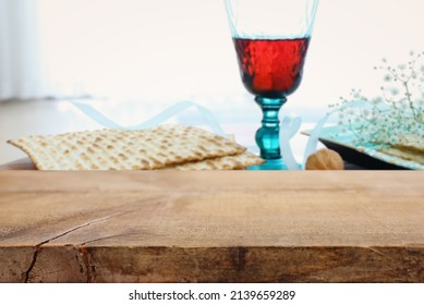 Empty table for product display in front of Passover background. Glass Wine cup and matzoh (jewish holiday bread)