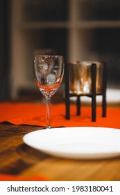 Empty table with a red tablecloth served for the reception of guests for dinner. Plates and glasses on a table in a cafe and restaurant. Clean dishes.