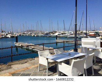 Empty Table Of A Restaurant With Harbor View In Lanzarote, Playa Blanca, Spain