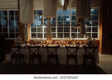 Empty table is set for a wedding reception with flowers, candles, and elegant decorations
