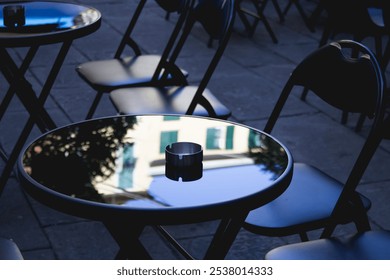 Empty table in street cafe reflecting building and sky - Powered by Shutterstock