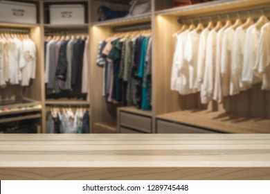 Empty Table Top For Product Display Montage. Fashion And Clothes Concept. Walk In Closet Wardrobe Blurred In The Background.