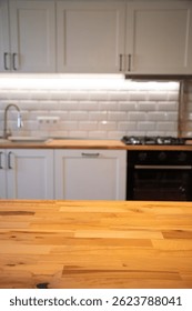Empty tabletop over defocused kitchen with copy space