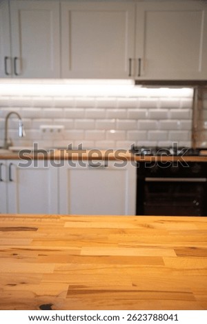 Empty tabletop over defocused kitchen with copy space