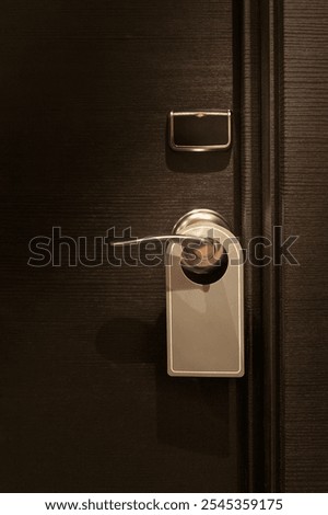 Empty tag in  do not disturb sign hanging on elegant hotel room door