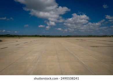 Empty tarmac at an airport with a blue sky and white clouds 001  - Powered by Shutterstock