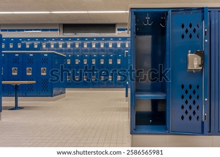 Empty team locker, locker room, changing room, with an open locker, with traditional blue metal lockers.	