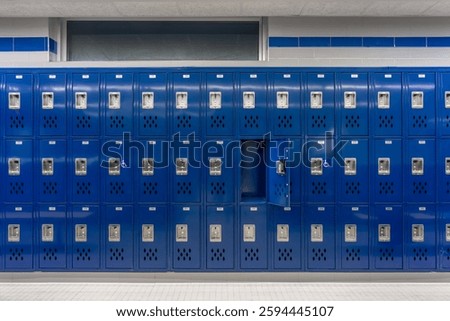 Empty team locker room, changing room, with an open locker, with traditional blue metal lockers.