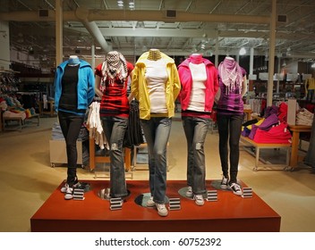 An Empty Teenage Fashion Store With Five Mannequin Displaying The Latest Trend With Jeans, Hoodies, T-shirts And Scarfs.