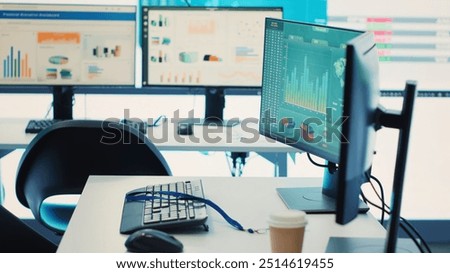 Empty telecommunications control room with workstations, coworking space equipped with a big screen and modern devices used in organizational daily tasks and projects. Camera A.