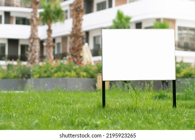 Empty template, advertising mock-up, banner on grass near pavement in city green park.Copy space for text.Information board on white background.  - Shutterstock ID 2195923265