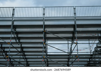 Empty temporary stadium bleachers, gray metal seats, neutral background, no spectators, industrial and minimalistic sports architecture.