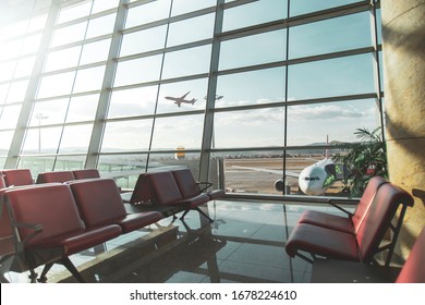 An empty terminal, aircrafts are waiting and preparing for their next flight and one of them taken off - Powered by Shutterstock