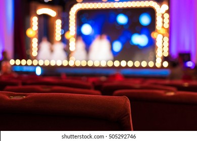 Empty Theater Chairs And Blurred Stage Lights