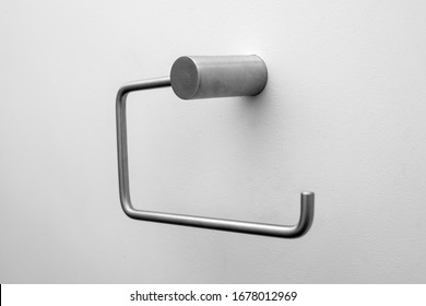 An Empty Toilet Roll Holder On A White Wall