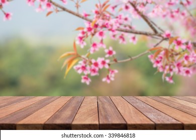 Empty top wooden table and flower field blurred background. Can use for product display
