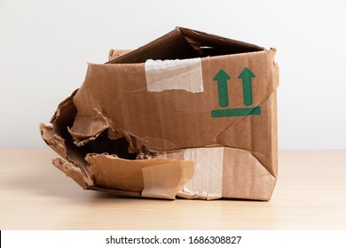 Empty Torn And Wrinkled Cardboard Box. Concept Of Shopping, Delivery And Cargo Insurance.